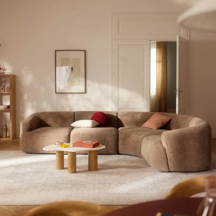 Light brown Oro Cloud Sectional Sofa in a modern living room with curved design.