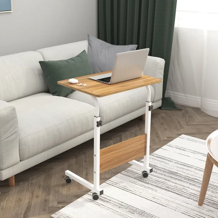 Bed Table oak 2 Oak wood bed table with a white metal frame, adjustable height, and rolling wheels, holding a laptop, ideal for use on a couch or bed.