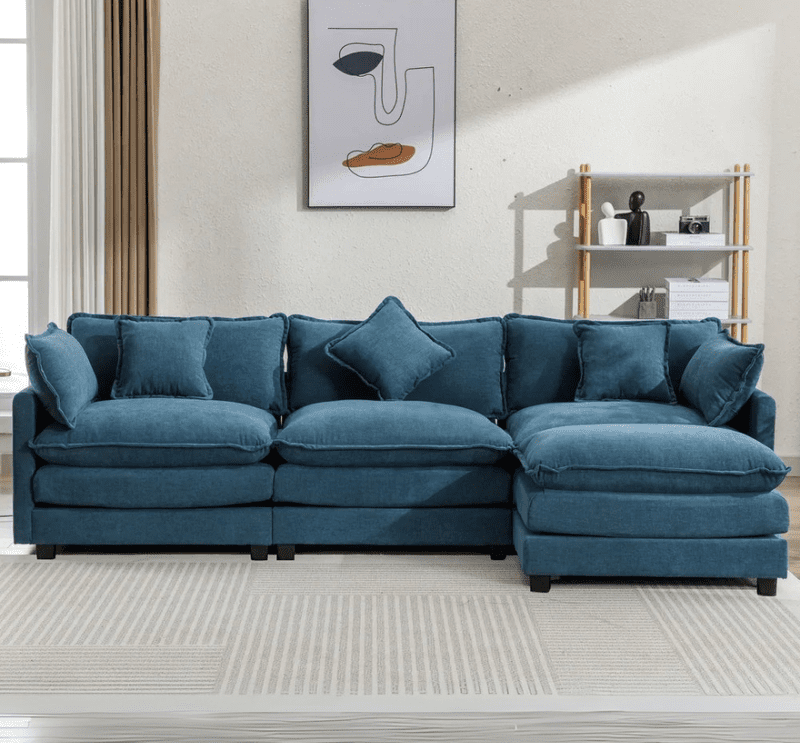 Amore Upholstered Sofa 1 Amore Upholstered Sofa in a luxury living room setting, featuring a spacious, modern design with premium fabric upholstery, perfect for elegant homes in Pakistan and the UAE.